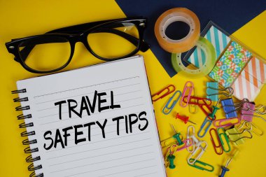 Seyahat Güvenliği İpuçları metni, sarı arka planda gözlük ve kırtasiye malzemesi.
