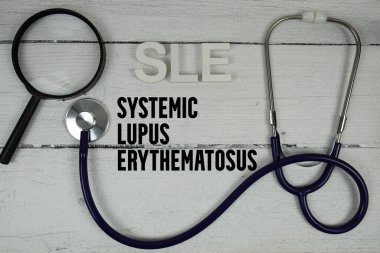 SLE Sistemik Lupus Eritematozus metin üzerinde stetoskop ahşap arkaplan
