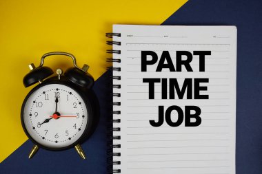 Not defterine yazılan yarı zamanlı iş metni ve sarı arkaplanda alarm saati