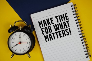 Ne olursa olsun zaman ayır! Sarı zemin üzerinde alarm saati olan not defterine yazılan metin