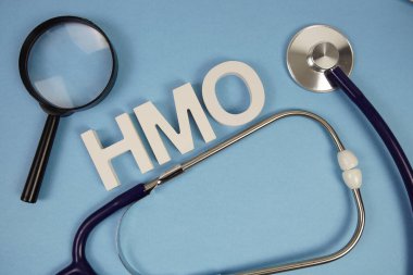 Sağlık Bakım Örgütü alfabesinin kısaltması. Mavi arka planda büyüteç ve steteskop var.