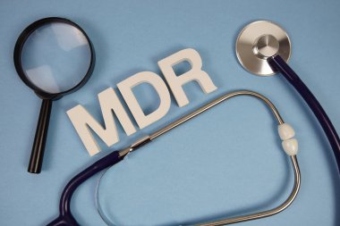 Medikal Aygıt Yönetmeliği alfabe harflerinin kısaltması büyüteç ve mavi arka planda steteskop