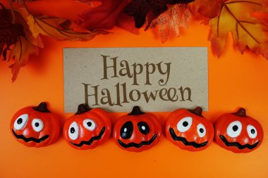 Turuncu arkaplandaki element dekorasyonlu Cadılar Bayramı metni