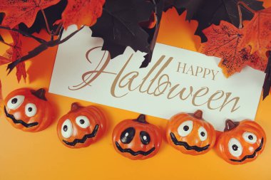 Turuncu arkaplandaki element dekorasyonlu Cadılar Bayramı metni