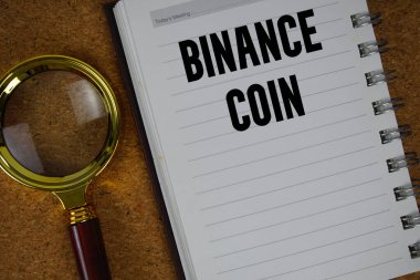 Defter kağıdına büyüteçle yazılmış Binance Sikkesi metni