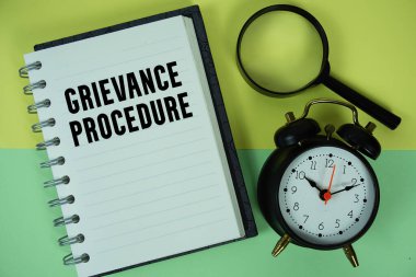 Defter kağıdına büyüteç ve alarm saati ile yazılmış şikayet prosedürü metni