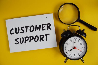 Müşteri destek mektupları büyüteç ve alarm saati düz sarı zemin üzerinde yatıyordu