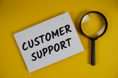 Müşteri Destek mektupları sarı arka planda yatıyordu büyüteç düz