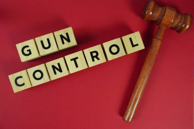 Hukuk temalı silah kontrol alfabesi harfleri, hakim dairesinin tokmağı ya da tokmağı sarı arka planda yatıyordu.