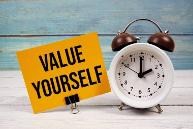 Tahta arkaplanda alarmlı saat yazılı kağıt kartınıza yazdığınız değer