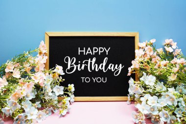 Mutlu yıllar sana pembe ve mavi arkaplanda çiçek desenli kısa mesaj