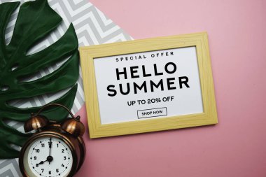 Merhaba Yaz İndirimi% 20 indirimli çalar saat ve pembe arka planda canavar yeşili yaprak