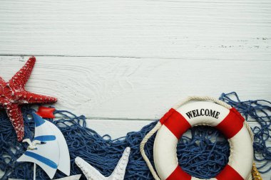 Yelkenli oyuncak model ve ahşap arka planda mavi balıkçı ağlı Lifebuoy.