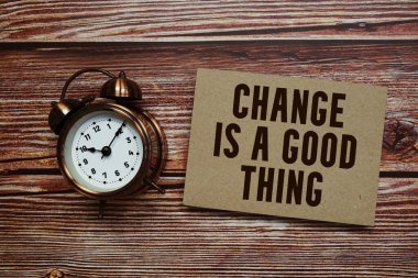 Chang iyi bir şey! Ahşap arkaplanda alarm saati olan metin