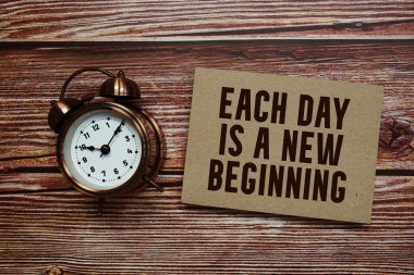 Her gün, ahşap zemin üzerinde alarm saati olan yeni bir başlangıç metni