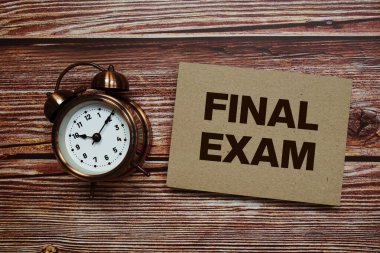 Tahta zemin üzerinde alarm saati olan son sınav metni