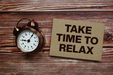 Ahşap arkaplanda alarm saatiyle metni gevşetme zamanı