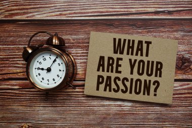 Tutkunuz nedir? Ahşap arkaplanda alarm saati olan metin