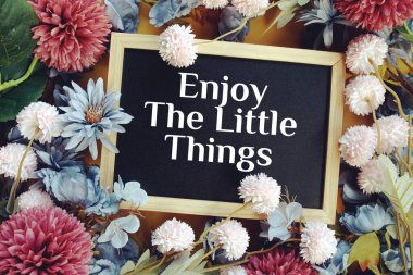 Sarı arka planda çiçek süslemesi olan Küçük Zımbırtı metninin tadını çıkar