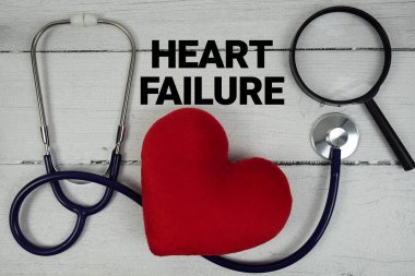 Kalp yetmezliği metni, kırmızı kalp, büyüteç ve ahşap arka planda tıbbi steteskop.