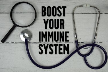 Tahta zemin üzerinde büyüteç ve tıbbi stetoskop bulunan Bağışıklık Sistemi metninizi yükseltin
