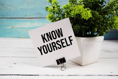 Tahta arka planda kağıt kartın üzerine yazılan kendini bil