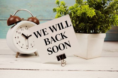 Yakında kağıt kartla yazılmış ve ahşap arka planda çalar saat olan metne geri döneceğiz.