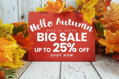 Merhaba Sonbahar Büyük Satış% 25 metin ve ahşap arka planda akçaağaç yaprağı süslenmiş