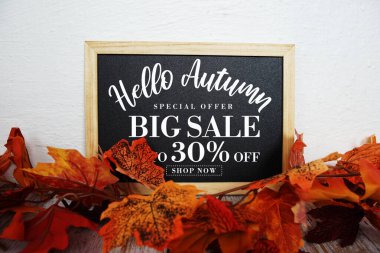 Merhaba Sonbahar Büyük Satış% 30 metin ve ahşap arka planda akçaağaç yaprağı süslemesi