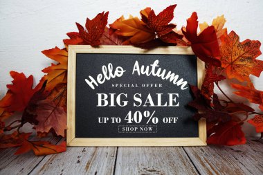 Merhaba Sonbahar Büyük Satış% 40 metin ve ahşap arka planda akçaağaç yaprağı süslemesi