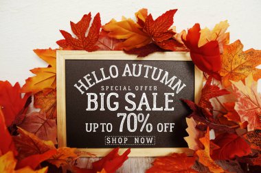 Merhaba Sonbahar Büyük Satış% 70 metin ve ahşap arka planda akçaağaç yaprağı süslemesi