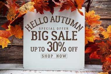 Merhaba Sonbahar Büyük Satış% 30 metin ve ahşap arka planda akçaağaç yaprağı süslemesi