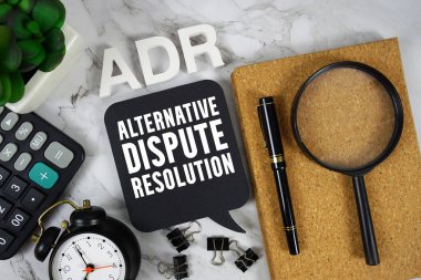 Hesaplayıcı, alarm saati ve mermer zemin üzerindeki büyüteçle ADR Alternatif Tartışma Çözümleme metni