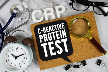 CRP - Stetoskop, alarm saati ve mermer zemin üzerinde büyüteç bulunan C-Reaktif Protein Test metni