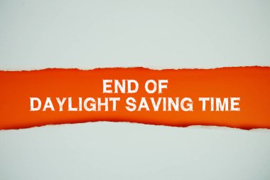 Gün Işığı Tasarruf Zamanı metni turuncu üzerine yatay yırtılmış beyaz kağıt