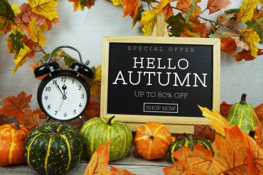 Sonbahar İndirimi% 80 metin alarm saati ve ahşap zemin üzerinde akçaağaç yaprağı süslemesi