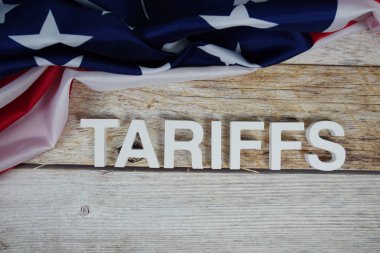 Ahşap arka planda ABD bayrağı bulunan tarifeler.