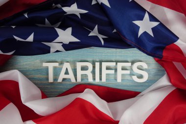 Ahşap arka planda ABD bayrağı bulunan tarifeler.