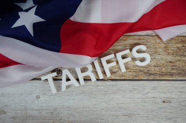 Ahşap arka planda ABD bayrağı bulunan tarifeler.