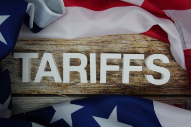 Ahşap arka planda ABD bayrağı bulunan tarifeler.