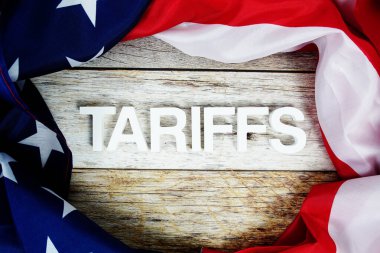 Ahşap arka planda ABD bayrağı bulunan tarifeler.