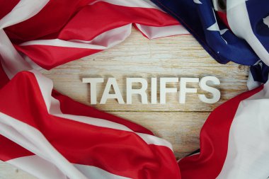 Ahşap arka planda ABD bayrağı bulunan tarifeler.