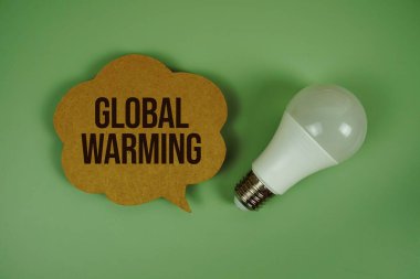 Yeşil zemin üzerinde ampul bulunan küresel ısınma metni