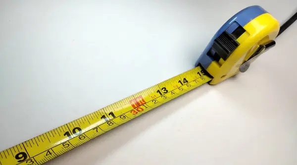 Close up of a tape measure on a white background with copy space