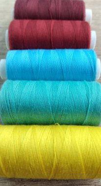 Beyaz kumaş arka planında çok renkli iplikler.