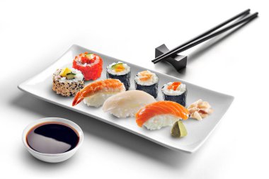 Plate of sushi with soy sauce and chopsticks isolated on white background