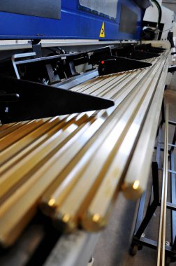 Detail of brass bar loader on lathe for CNC machining In the fittings industry