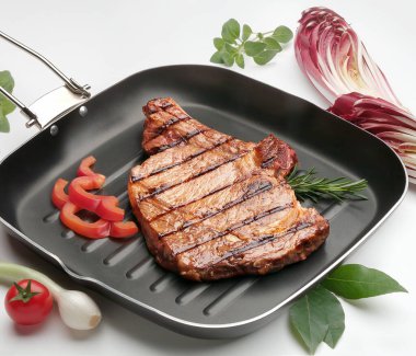 Izgara tavasında sebzelerle pişirilmiş biftek kaburgası.