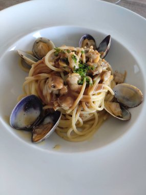 Yuvarlak beyaz tabak midyeli spagetti.