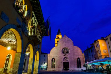 Muggia Trieste, İtalya - 7 Haziran 2023: Muggia Trieste meydanındaki katedralin ve belediye binasının gece manzarası